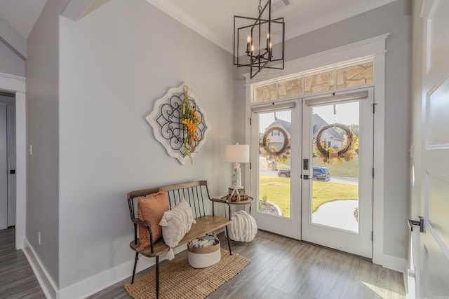 doorway to outside with dark hardwood / wood-style flooring, high vaulted ceiling, and a notable chandelier