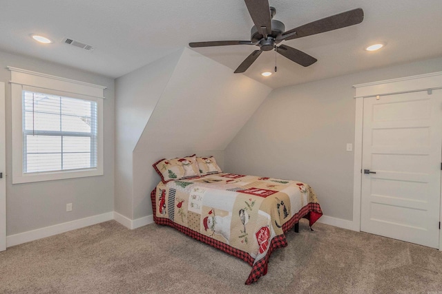 carpeted bedroom with ceiling fan and vaulted ceiling