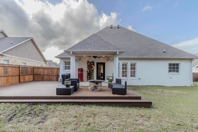 rear view of house featuring a lawn, ceiling fan, an outdoor living space with a fire pit, and a deck