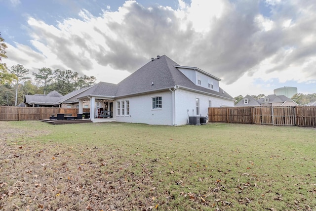 back of property with a lawn, cooling unit, and a patio area