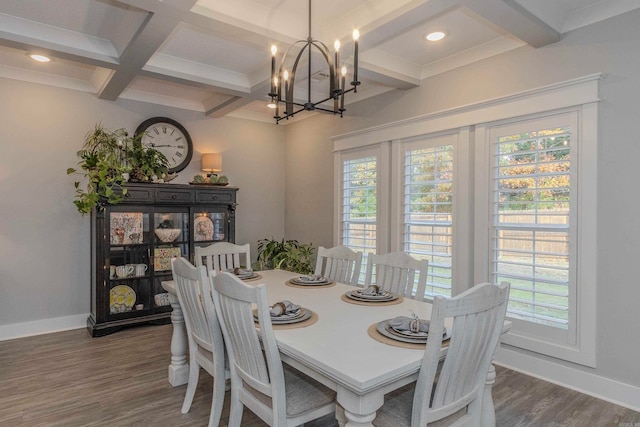 dining area featuring coffered ceiling, a healthy amount of sunlight, dark hardwood / wood-style floors, and a notable chandelier