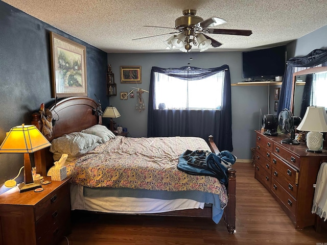 bedroom with multiple windows, ceiling fan, dark hardwood / wood-style flooring, and a textured ceiling