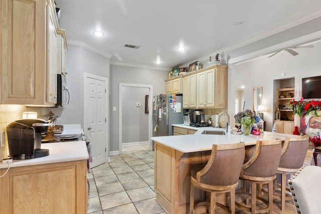 kitchen featuring sink, stainless steel appliances, kitchen peninsula, crown molding, and light brown cabinetry