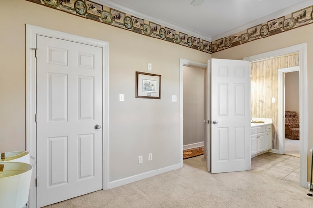 unfurnished bedroom featuring crown molding, light carpet, and connected bathroom