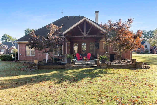 rear view of house with a lawn and a patio