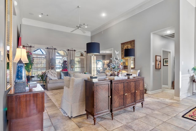 living room with ceiling fan, a high ceiling, and ornamental molding