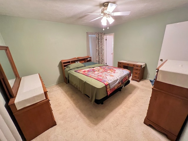 carpeted bedroom featuring ceiling fan and a textured ceiling