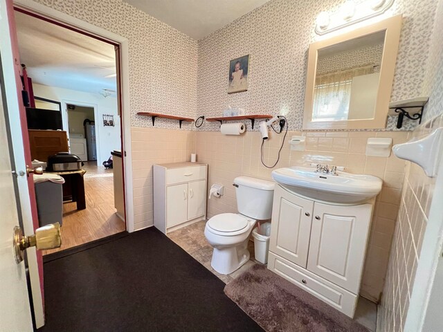 bathroom featuring hardwood / wood-style floors, vanity, toilet, and tile walls