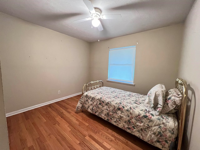 bedroom featuring wood-type flooring, a textured ceiling, and ceiling fan