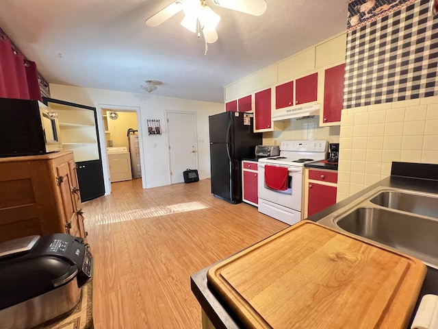 kitchen with white range with electric cooktop, black refrigerator, tile walls, light hardwood / wood-style floors, and washer / dryer