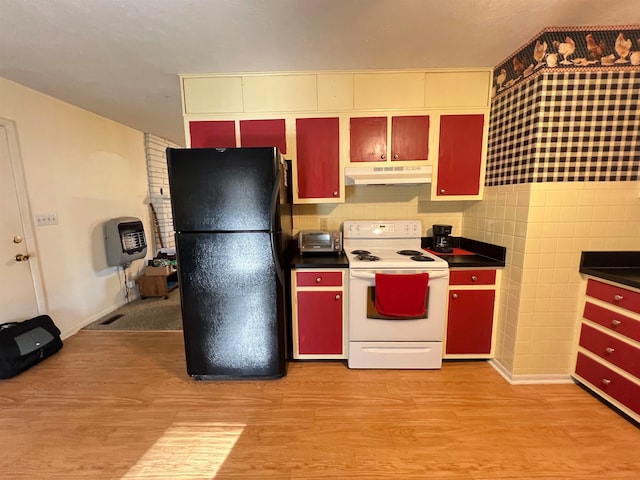 kitchen with heating unit, black fridge, electric stove, and light hardwood / wood-style flooring