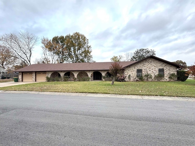 ranch-style home featuring a garage and a front yard