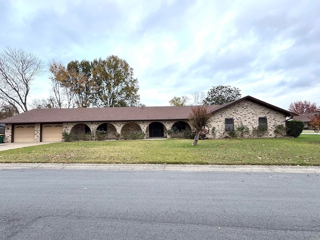 ranch-style house featuring a garage and a front lawn