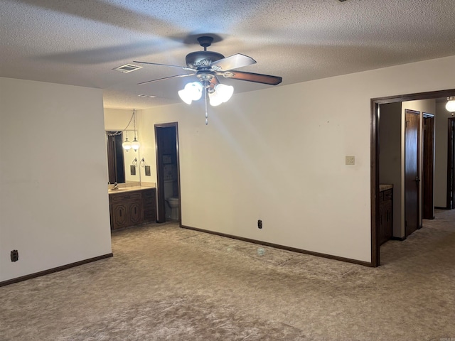 unfurnished room featuring light carpet, ceiling fan, and a textured ceiling