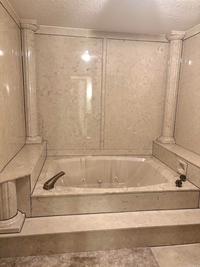 bathroom with a washtub and a textured ceiling