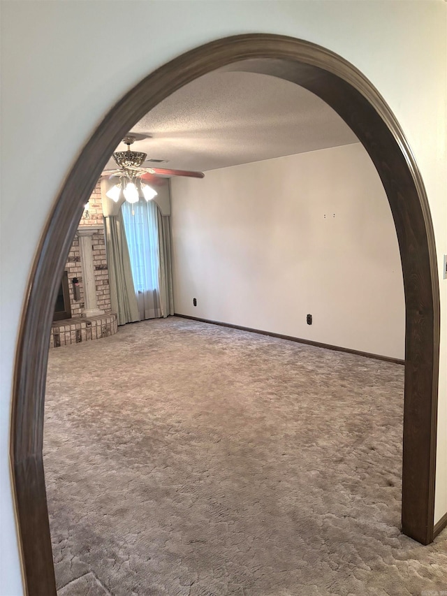 unfurnished room with ceiling fan, carpet floors, and a textured ceiling