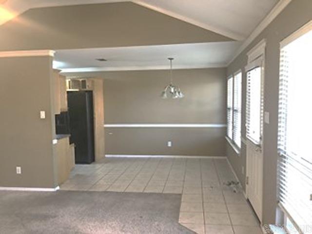 interior space with tile patterned floors, an inviting chandelier, and vaulted ceiling