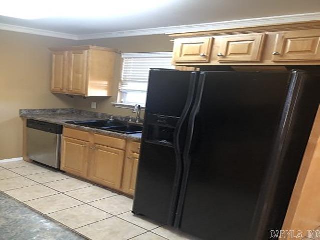 kitchen featuring dishwasher, sink, black fridge, light tile patterned floors, and ornamental molding