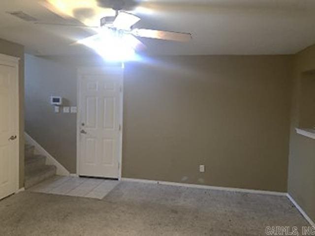 carpeted spare room featuring ceiling fan