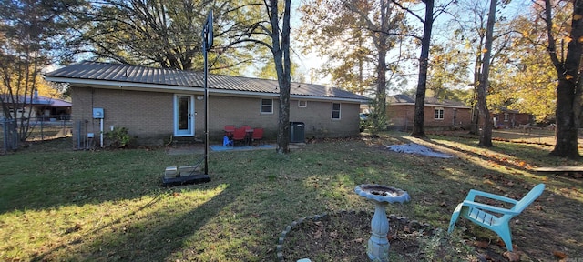 back of property featuring a patio area, a yard, cooling unit, and an outdoor fire pit