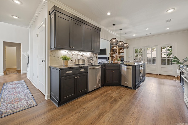 kitchen featuring dishwasher, backsplash, hanging light fixtures, ornamental molding, and light hardwood / wood-style floors