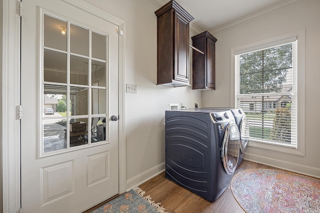 laundry area featuring hardwood / wood-style flooring, cabinets, separate washer and dryer, and crown molding