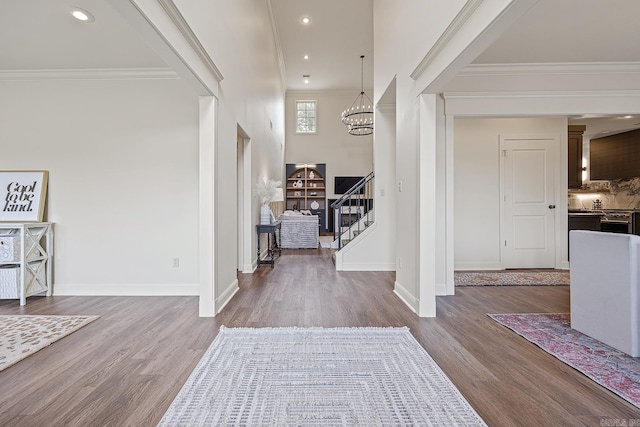 foyer entrance featuring ornamental molding, dark hardwood / wood-style floors, and a notable chandelier