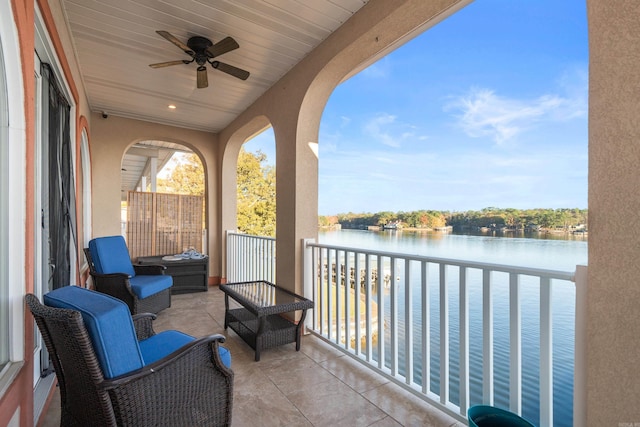 balcony featuring a water view and ceiling fan