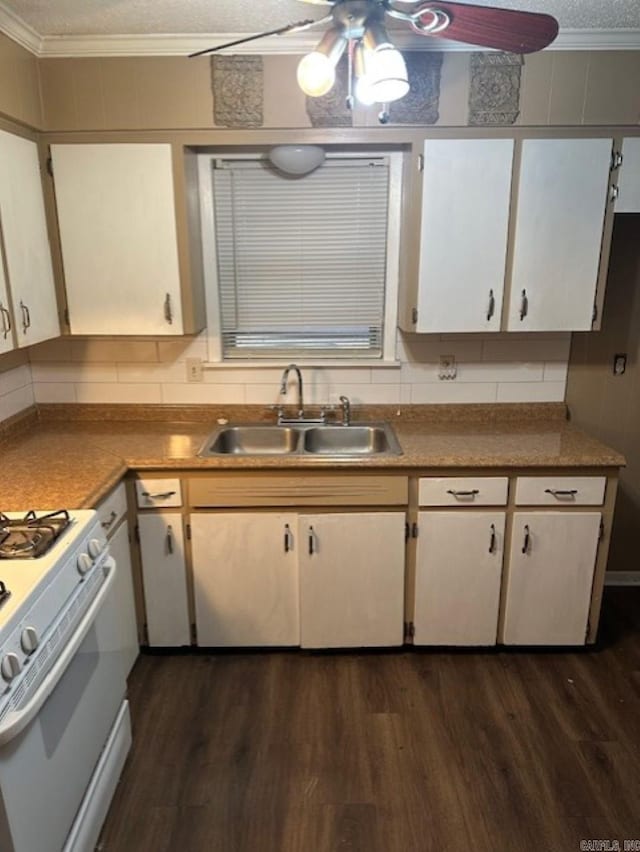 kitchen with dark wood-type flooring, crown molding, sink, white gas range, and white cabinetry