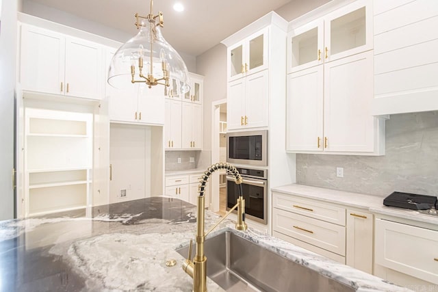 kitchen with white cabinets, appliances with stainless steel finishes, and backsplash