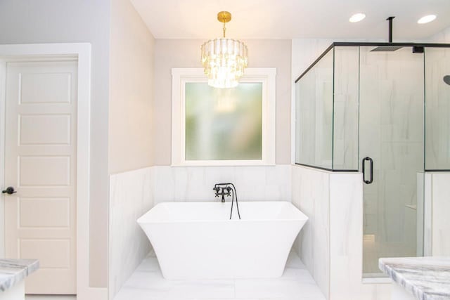 bathroom with shower with separate bathtub and an inviting chandelier