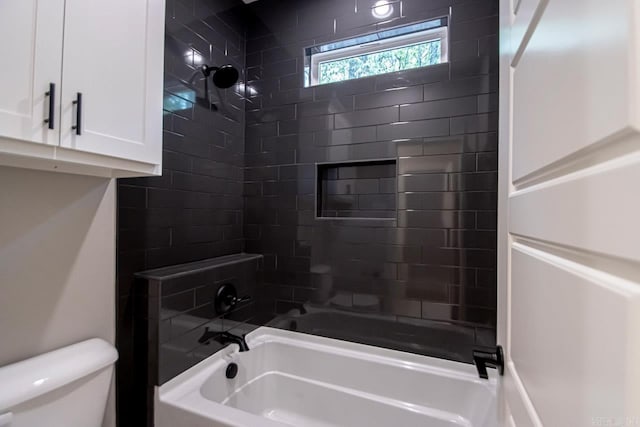 bathroom featuring toilet and tiled shower / bath