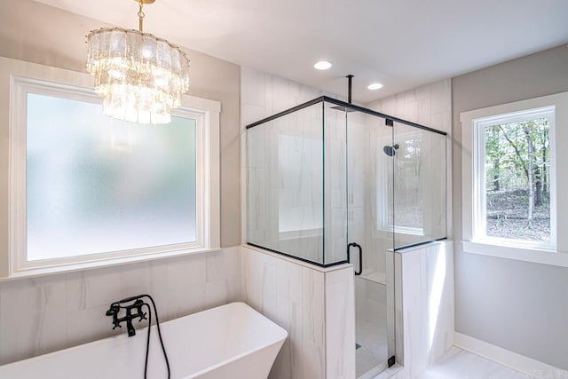 bathroom with separate shower and tub and a notable chandelier