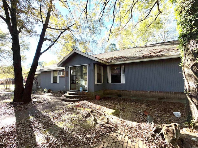 view of side of home with a wall mounted air conditioner and a patio