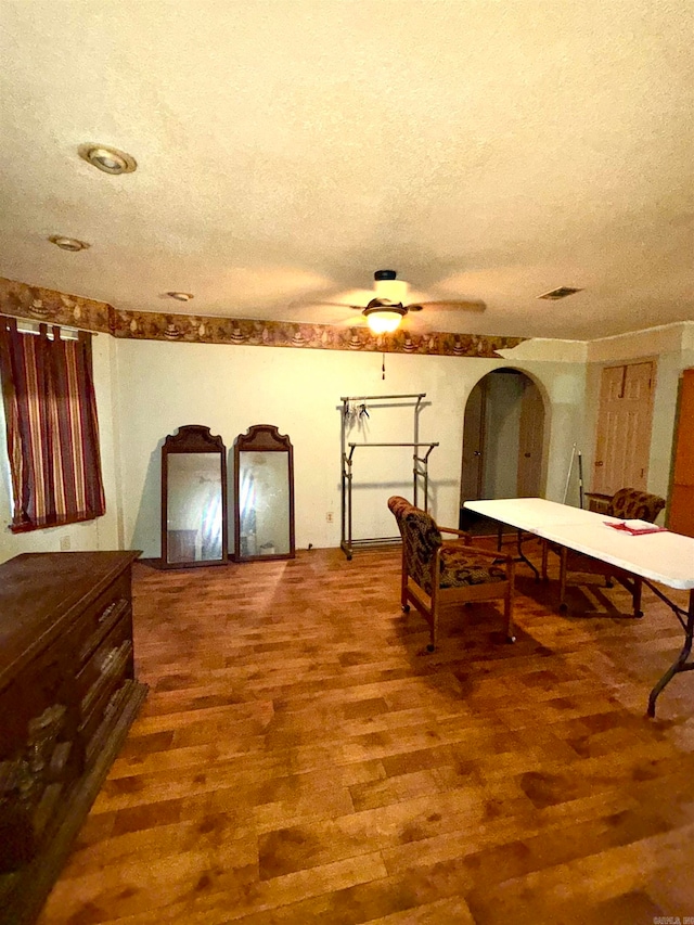 dining room with ceiling fan, hardwood / wood-style floors, and a textured ceiling