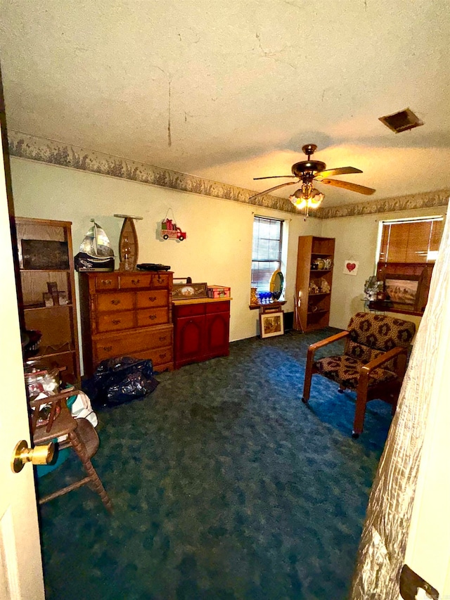 carpeted bedroom with a textured ceiling and ceiling fan