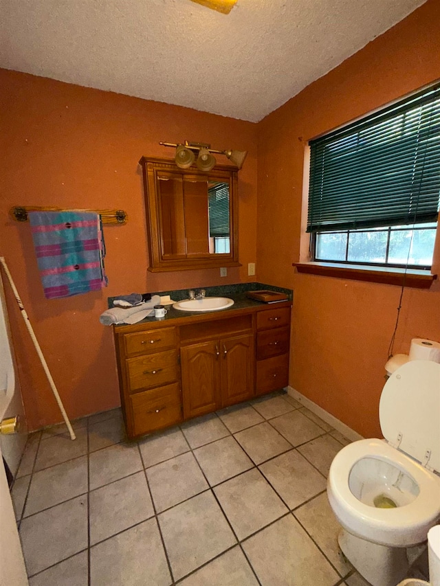 bathroom with tile patterned flooring, vanity, and a textured ceiling