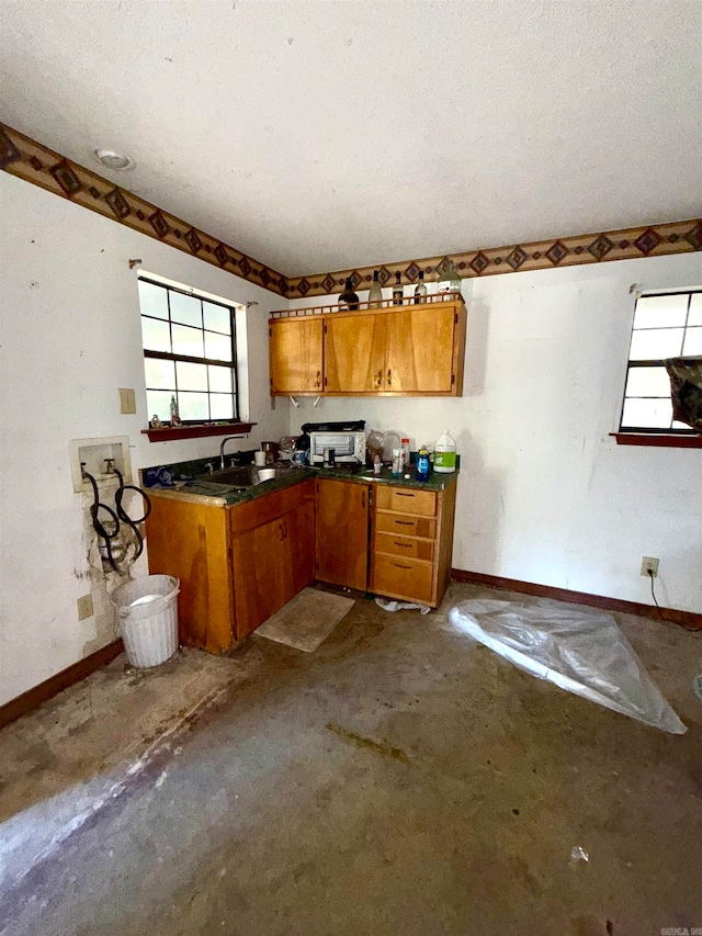 kitchen featuring sink, concrete floors, and a textured ceiling