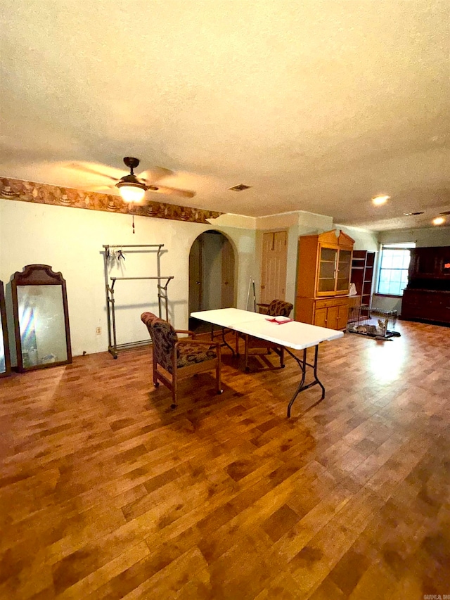 game room featuring a textured ceiling, hardwood / wood-style flooring, and ceiling fan