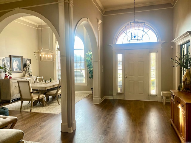 foyer with a chandelier, dark hardwood / wood-style floors, and ornamental molding