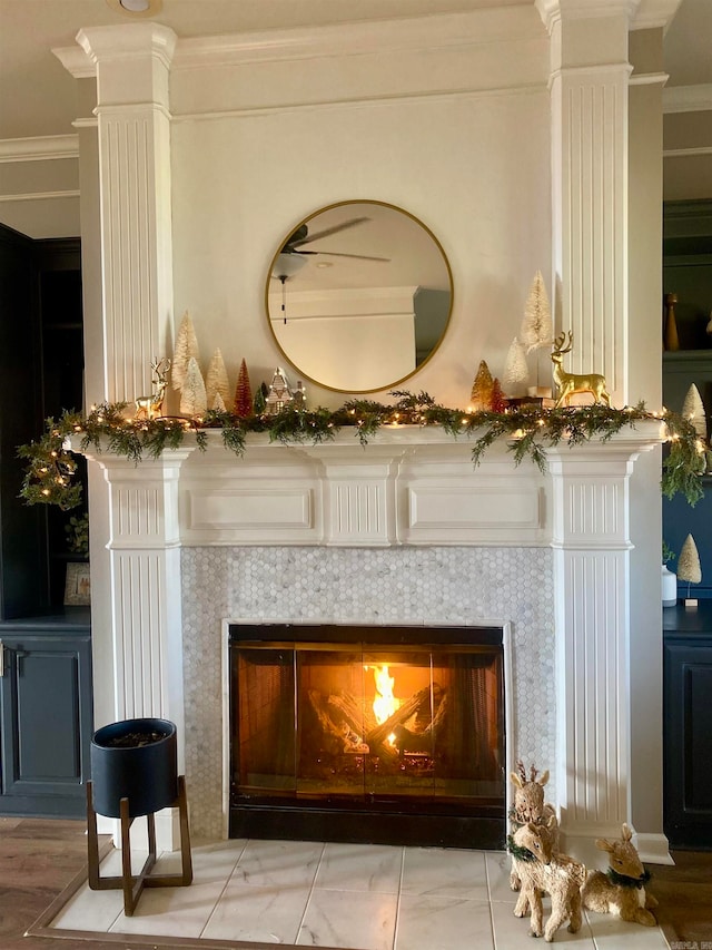 room details featuring a fireplace, hardwood / wood-style flooring, ornate columns, and crown molding