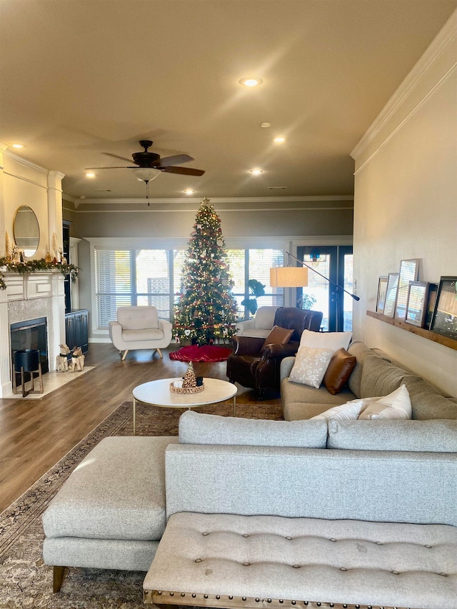 living room featuring hardwood / wood-style flooring, a healthy amount of sunlight, and ornamental molding