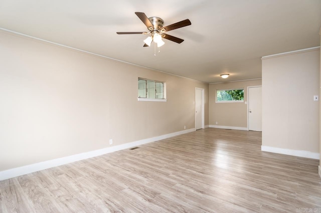 spare room featuring ceiling fan, light wood-type flooring, and crown molding