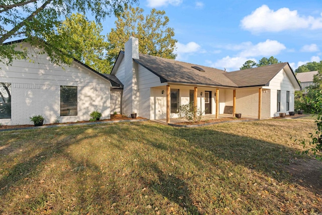 back of property with a yard and a patio area