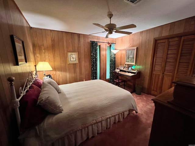 carpeted bedroom with ceiling fan and wood walls