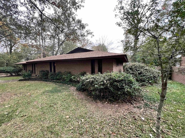 view of side of home with a yard