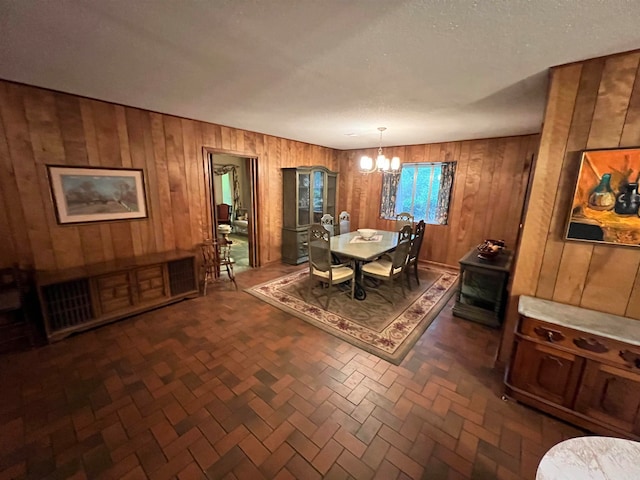 dining space featuring wood walls and a chandelier