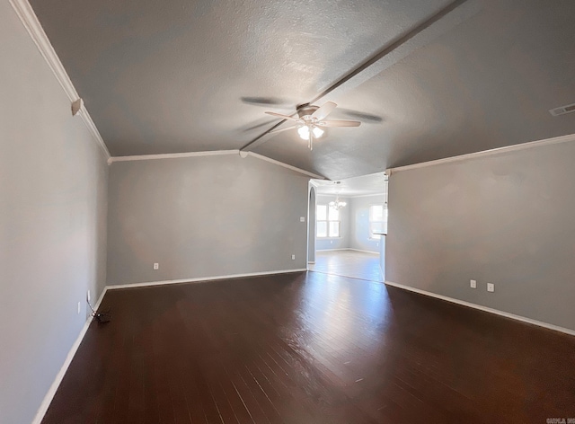 interior space with ceiling fan with notable chandelier, dark hardwood / wood-style flooring, a textured ceiling, and vaulted ceiling