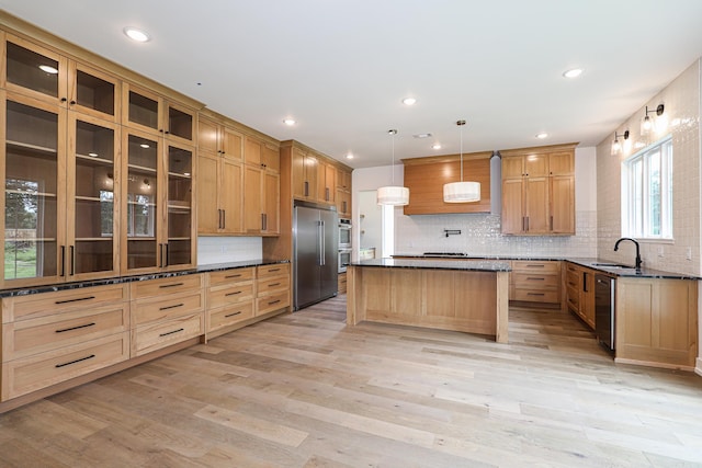 kitchen with pendant lighting, sink, light hardwood / wood-style floors, a kitchen island, and stainless steel appliances