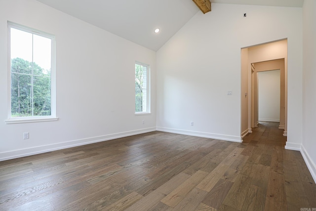 unfurnished room featuring vaulted ceiling with beams, plenty of natural light, and dark wood-type flooring